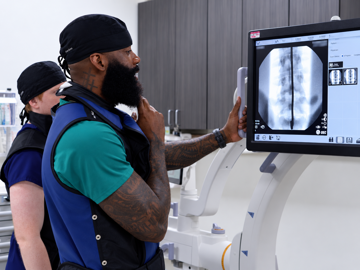 Dr. David Nwokeabia reviewing fluoroscopic spine imaging in the procedure suite